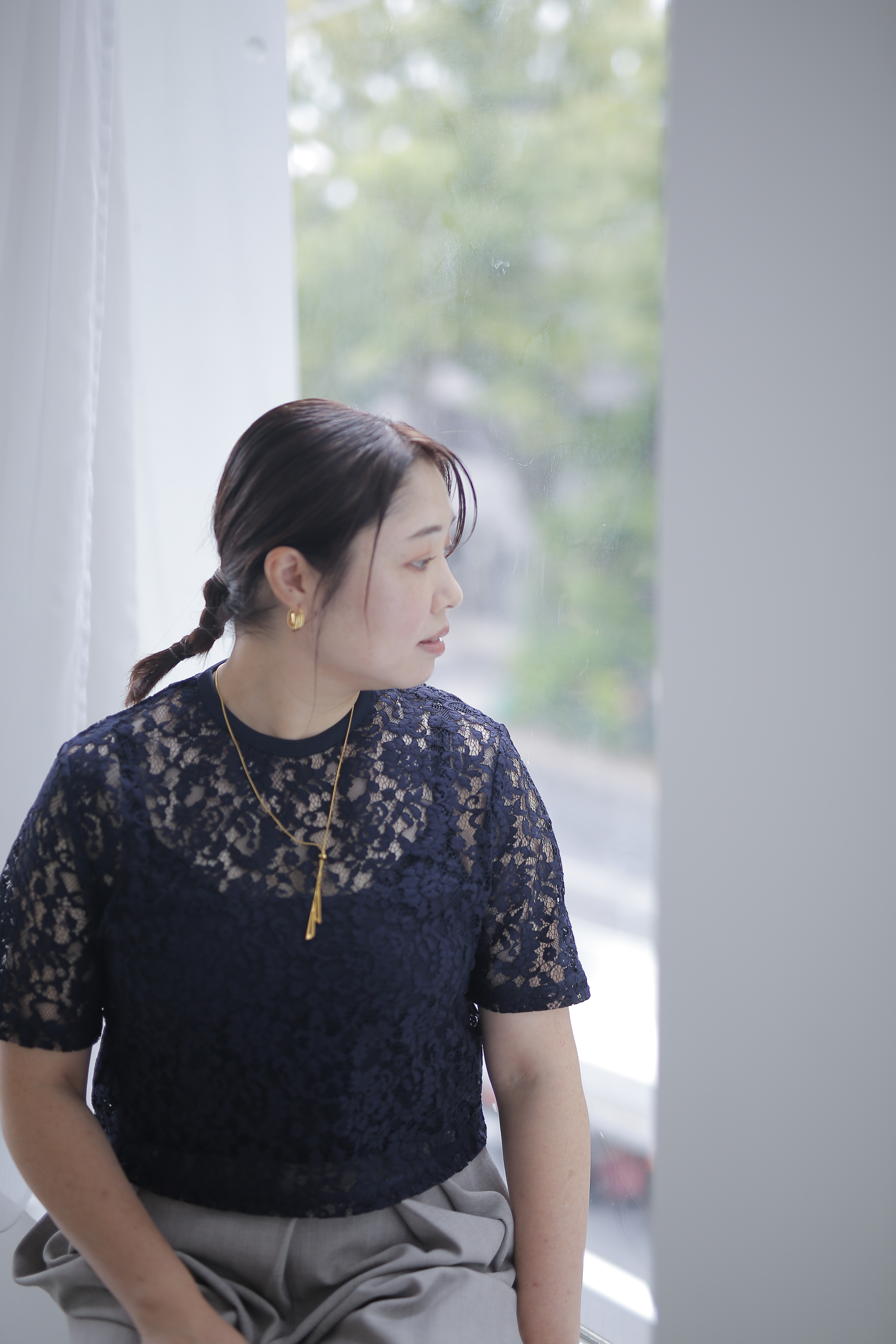 窓辺で外を見つめる今村里沙